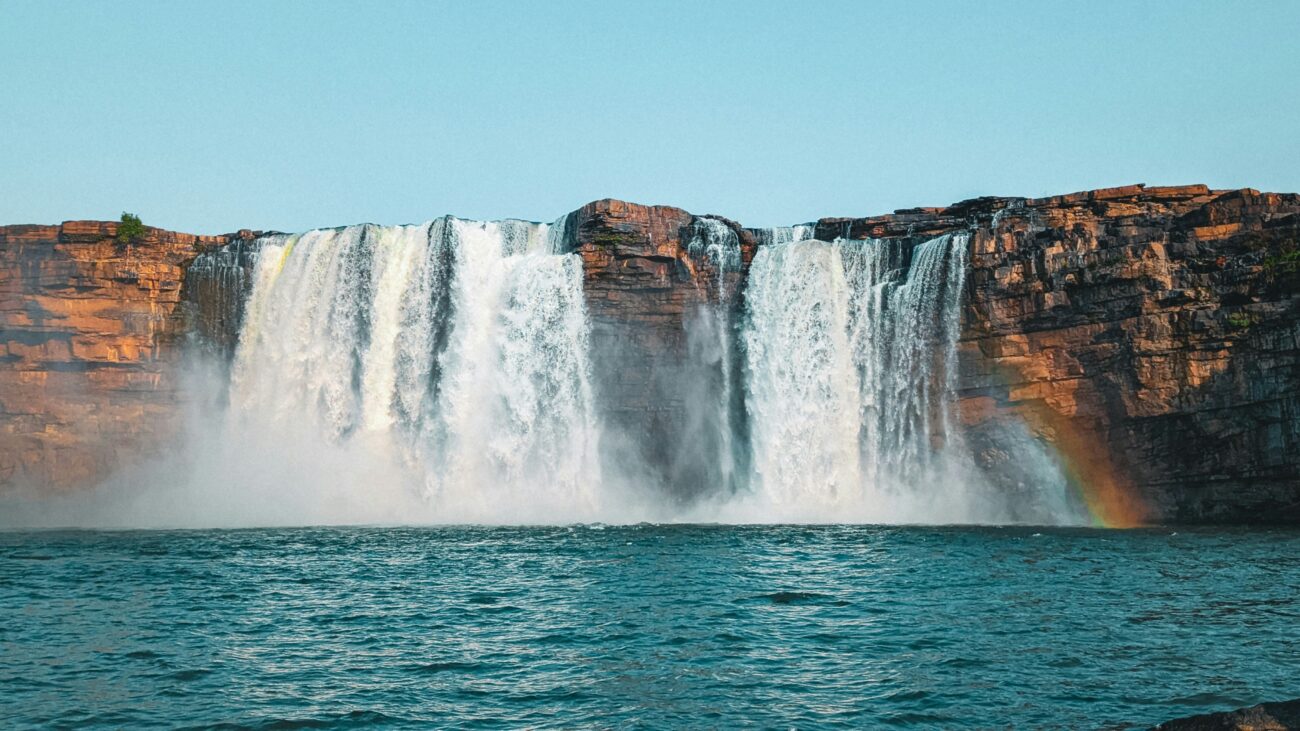 Chitrakoot Falls cascading over cliffs amidst lush greenery under a vibrant Chhattisgarh sky
