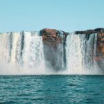 Chitrakoot Falls cascading over cliffs amidst lush greenery under a vibrant Chhattisgarh sky