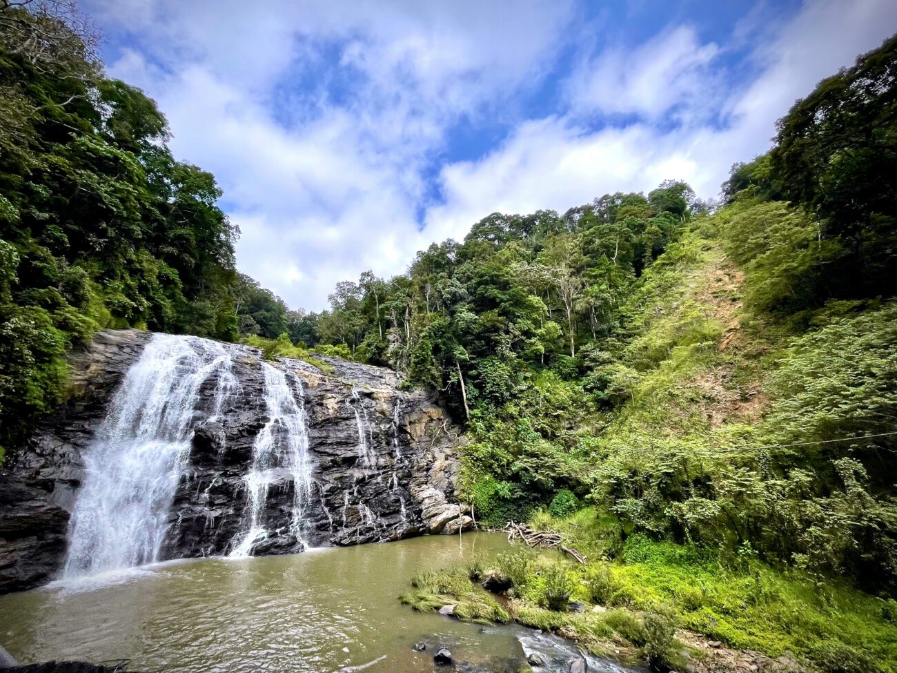 Coorg’s misty coffee plantations and cascading waterfalls under a vibrant Karnataka sky