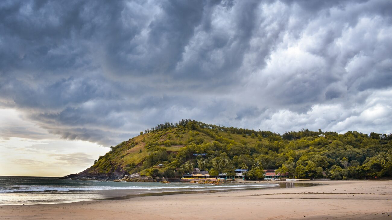 Gokarna’s serene Om Beach and Mahabaleshwar Temple under a vibrant Karnataka sunset