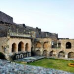 Golconda Fort’s grand stone walls and domes under a vibrant Hyderabad sunset