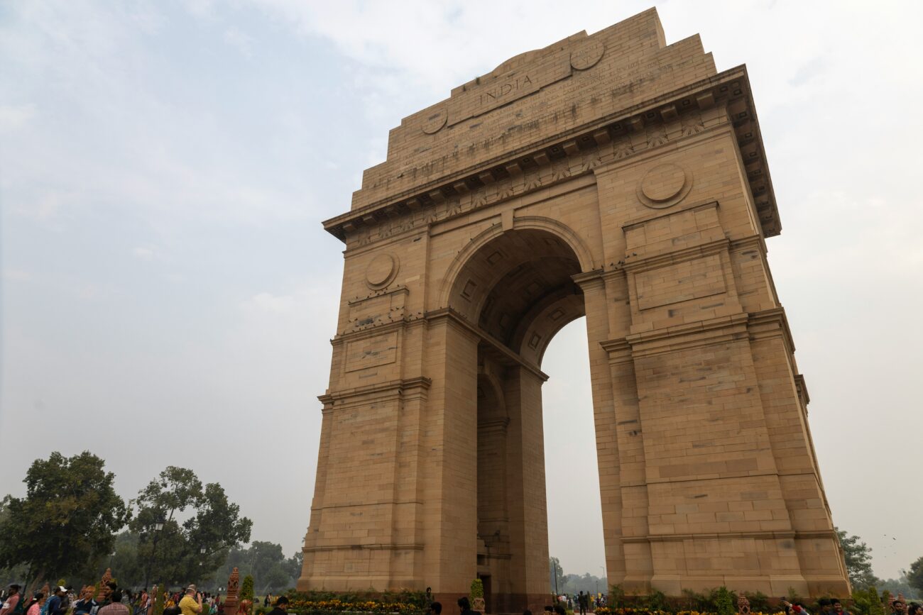 India Gate’s illuminated archway at dusk with sprawling lawns in Delhi
